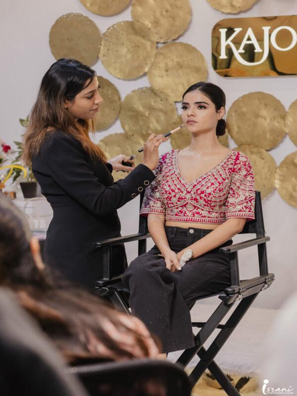 Makeup artist demonstrating makeup application during a Kajol R Paswwan Academy class.