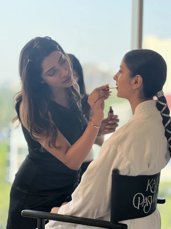 Makeup artist applying makeup to a client during a bridal makeup session.